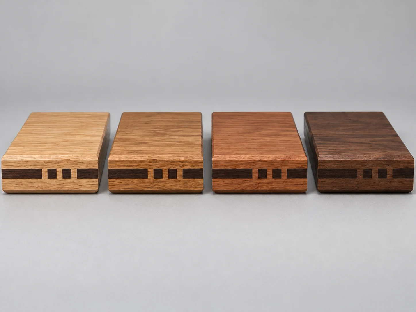 Four window sill offcuts in different hardwood finishes, each with the same dark inlay band on the front edge